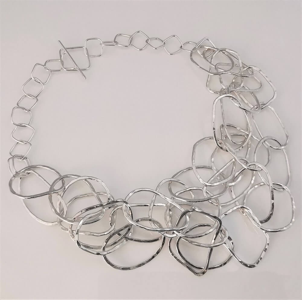 1. A Silver Triple Strand Interlinking Textured Hoop Necklace